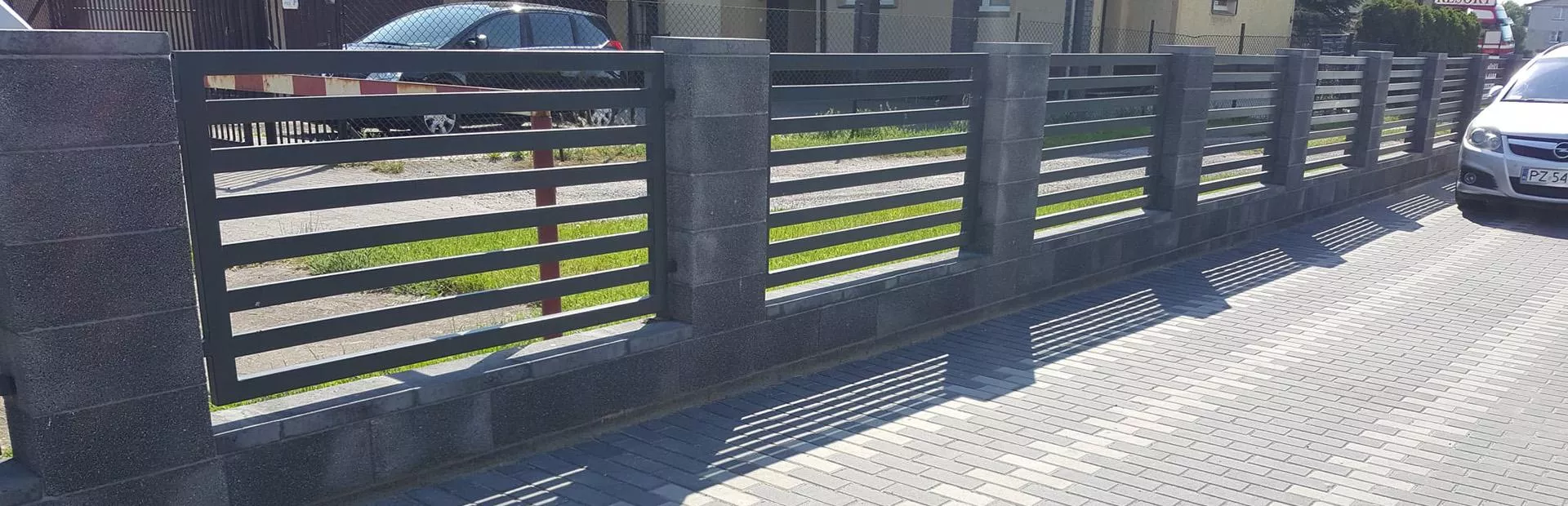 Metalowe ogrodzenie z betonowymi słupami
